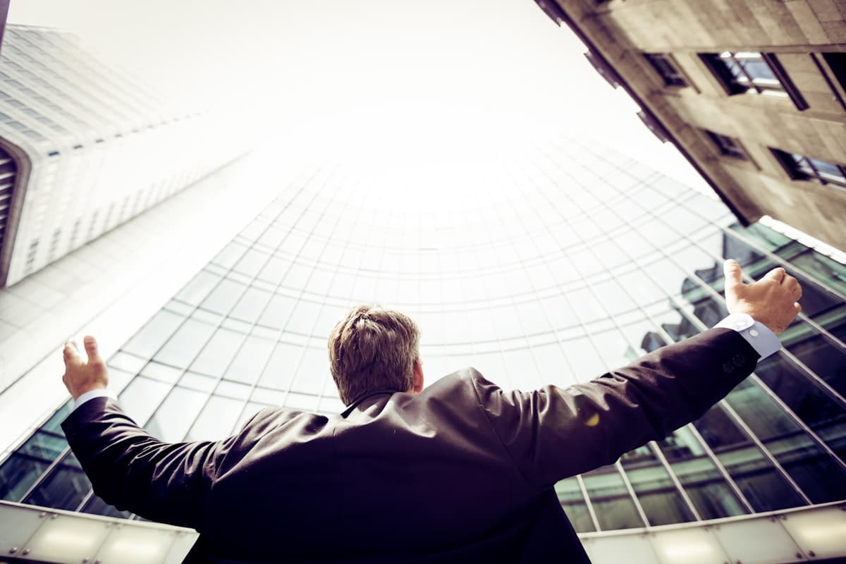 Professional looking upward among city towers, symbolizing career growth